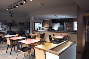a restaurant with tables and chairs and a kitchen at Fekete Sas Motel in Esztergom