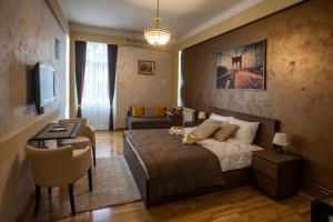a bedroom with a bed and a table and a chair at Knez Mihailova Apartman in Belgrade