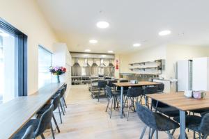 a restaurant with tables and chairs and a kitchen at Hobson Lodge in Auckland