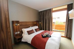 a hotel room with a bed with a red blanket at College Court Hotel in Leicester
