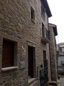 a stone building with two doors and a balcony at El Cobijo de los Arribes in Fermoselle