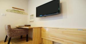 a tv hanging on a wall with a desk and a chair at 41-2 Surugamachi - Hotel / Vacation STAY 8328 in Nara