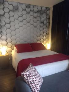 um quarto com uma cama grande e almofadas vermelhas e brancas em Studios Centro SP 16 em São Paulo