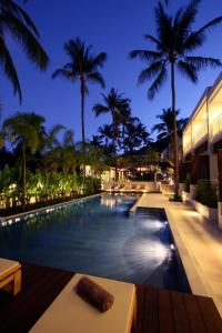 a swimming pool at night with palm trees at The Park Samui in Choeng Mon Beach
