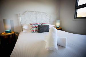 a bedroom with a white bed with towels on it at Pindara in Broke