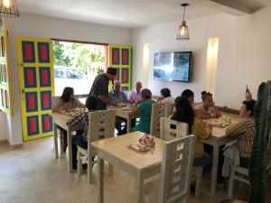 a group of people sitting at tables in a restaurant at 40 Amigos Hotel in Jardin