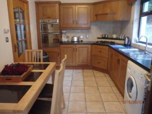 een keuken met houten kasten en een aanrechtblad bij Torrent Cottage in Coalisland +12 foto's