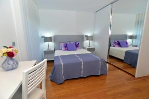 a bedroom with two beds with purple pillows and a mirror at Sec XXI 12 - 3 Bed Flat in Funchal