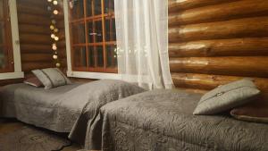 1 dormitorio con 2 camas y ventana en Hilupilttuu, en Tammela