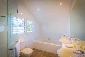 um banheiro com duas pias, uma banheira e um vaso sanitário em The Arthouse em Pokolbin mais 9 fotografias