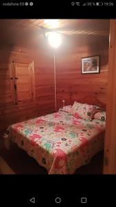 ein Schlafzimmer mit einem Bett in einem Holzzimmer in der Unterkunft Cabañas rurales la vega in Burunchel
