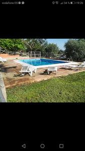 a large swimming pool sitting on top of a field at Cabañas rurales la vega in Burunchel