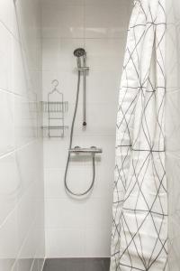 a shower in a bathroom with white tiles at Appartement Vacances Picardie in Amiens