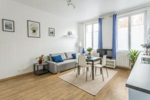 a living room with a couch and a table at Appartement Vacances Picardie in Amiens