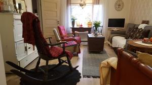 a living room with a rocking chair and a couch at Villa Vuorenpää in Tammela