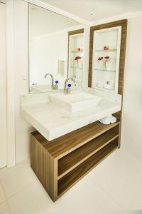 łazienka z dużą umywalką i lustrem w obiekcie Hospedaria das Brisas w mieście Praia do Rosa