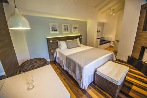 una camera d'albergo con letto, tavolo e sidro. di Hospedaria das Brisas a Praia do Rosa