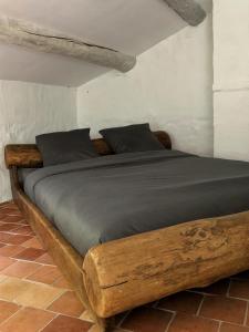 a bedroom with a wooden bed in a room at La Magnanerie d'Audabiac in Lussan +26 photos
