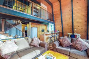 a living room with two couches and a kitchen at Canterbury Kings Beach Treehouse in Kings Beach