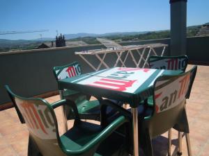 a green table and chairs on a roof at Albergue O Durmiñento in Sarria
