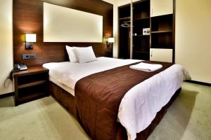 Boutique Hotel Golden Star في توزلا: غرفة نوم بسرير كبير وهاتف