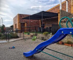 un parco giochi con scivolo blu di fronte a un edificio di Los Zafranales a Codo