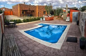 una piscina en un patio con un edificio de ladrillo en Los Zafranales, en Codo