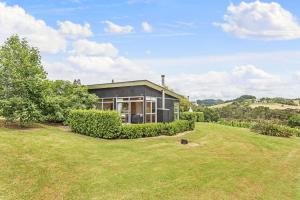 a house with a large yard in front of it at Riverside Matakana in Matakana