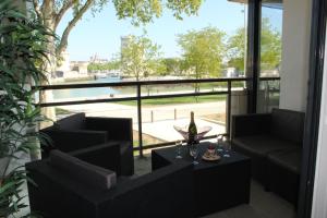 a living room with a large window with a bottle of wine at Vue exceptionnelle sur les Tours ! Charme et tranquillité in La Rochelle +7 photos