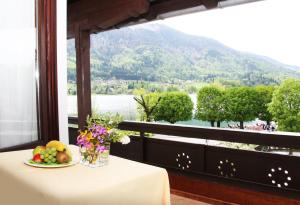 a table with a plate of fruit and a view of a mountain at Hotel-Restaurant Stefanihof in Fuschl am See