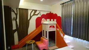ein Kinderzimmer mit Spielhaus und Rutsche in der Unterkunft Township Small Building B&B in Dongshan