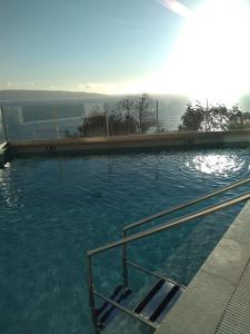 a large swimming pool with blue water in it at Departamento Reñaca maravillosa vista al mar in Viña del Mar