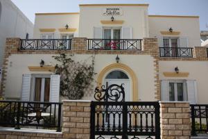 un edificio con una recinzione nera davanti di Pension Stella a Karterados