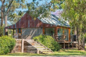 a home with a red barn with a porch at Two Doors in Broke