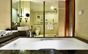 
a bathroom with a tub, sink and mirror at Chengdu Airport Hotel in Chengdu
