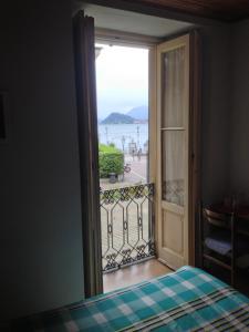 a door to a balcony with a view of the ocean at Albergo Il Vapore in Menaggio