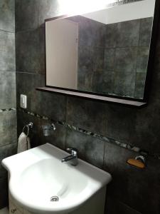 y baño con lavabo blanco y espejo. en Casa Fleming en Villa Carlos Paz