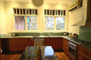 eine Küche mit einer Arbeitsplatte und einigen Fenstern in der Unterkunft Verona House in Pokolbin