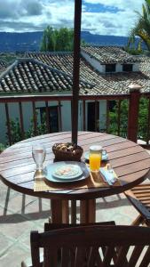 a wooden table with a plate of food and orange juice at HOTEL CAMPESTRE LA CASONA VILLA de LEYVA in Villa de Leyva