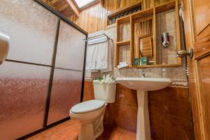 a bathroom with a toilet and a sink at Los Pinos Cabins & Reserve in Monteverde Costa Rica
