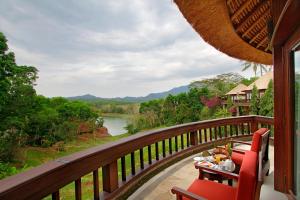 a table and chairs on a balcony with a view of a river at Taman Wana Resort Palasari in Negara