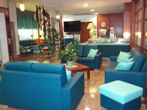 a living room with blue couches and a kitchen at Hotel Rivabella in Gallipoli