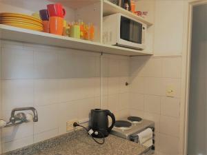 y cocina con fogones y microondas. en Apartamento Segui UNICO LUMINOSO en Buenos Aires