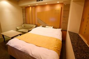 um quarto de hotel com uma cama e uma cadeira em Hotel Fine Garden Kosei (Adult Only) em Konan