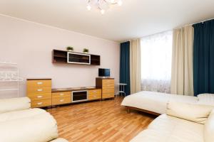 sala de estar con 2 sofás blancos y TV en Apartment Tatiana, en Yekaterinburg