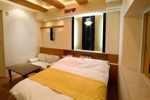 um pequeno quarto com uma cama, uma cadeira e uma janela em Hotel Fine Garden Kosei (Adult Only) em Konan