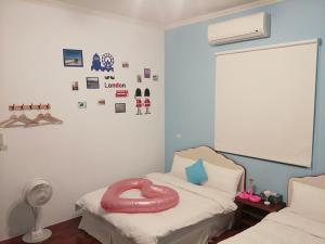 Shanshui Hai An Homestay في ماغونغ: غرفة بسرير عليها غرض وردي كبير
