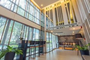 a lobby with a waiting area and windows at D Condo Nernpra Rayong in Rayong
