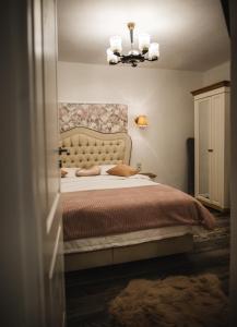 a bedroom with a bed and a chandelier at Glam Rose&White Downtown in Sibiu
