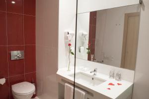 a bathroom with a sink and a toilet and a mirror at Flag Hotel Villa Aljustrel in Aljustrel